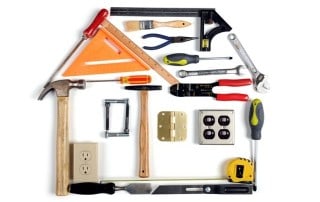 Hammer, saw, and tools arranged creatively in house shape for Western Slope real estate.