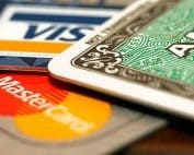VISA, MasterCard, and American Express credit cards on a table.