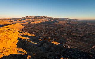 Aerial view of Grand Junction, Colorado at golden hour from the rocky cliffs of Colorado's Western Slope