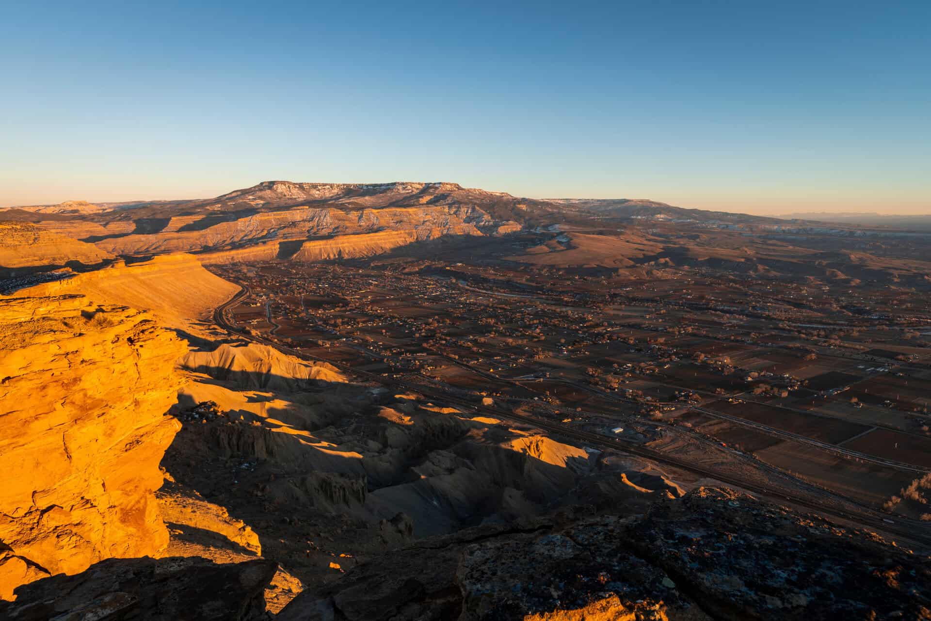 Aerial view of Grand Junction, Colorado at golden hour from the rocky cliffs of Colorado's Western Slope